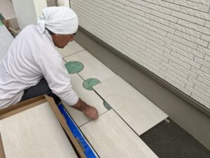 マスに合わせてタイルを張る職人さん